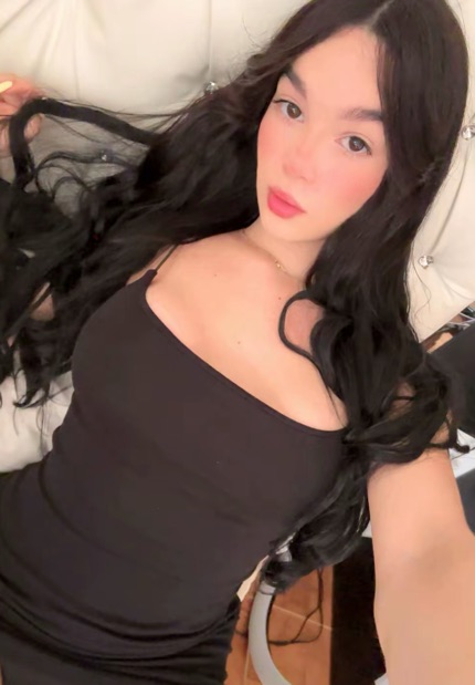 Woman with long dark hair in a black top looking into the camera